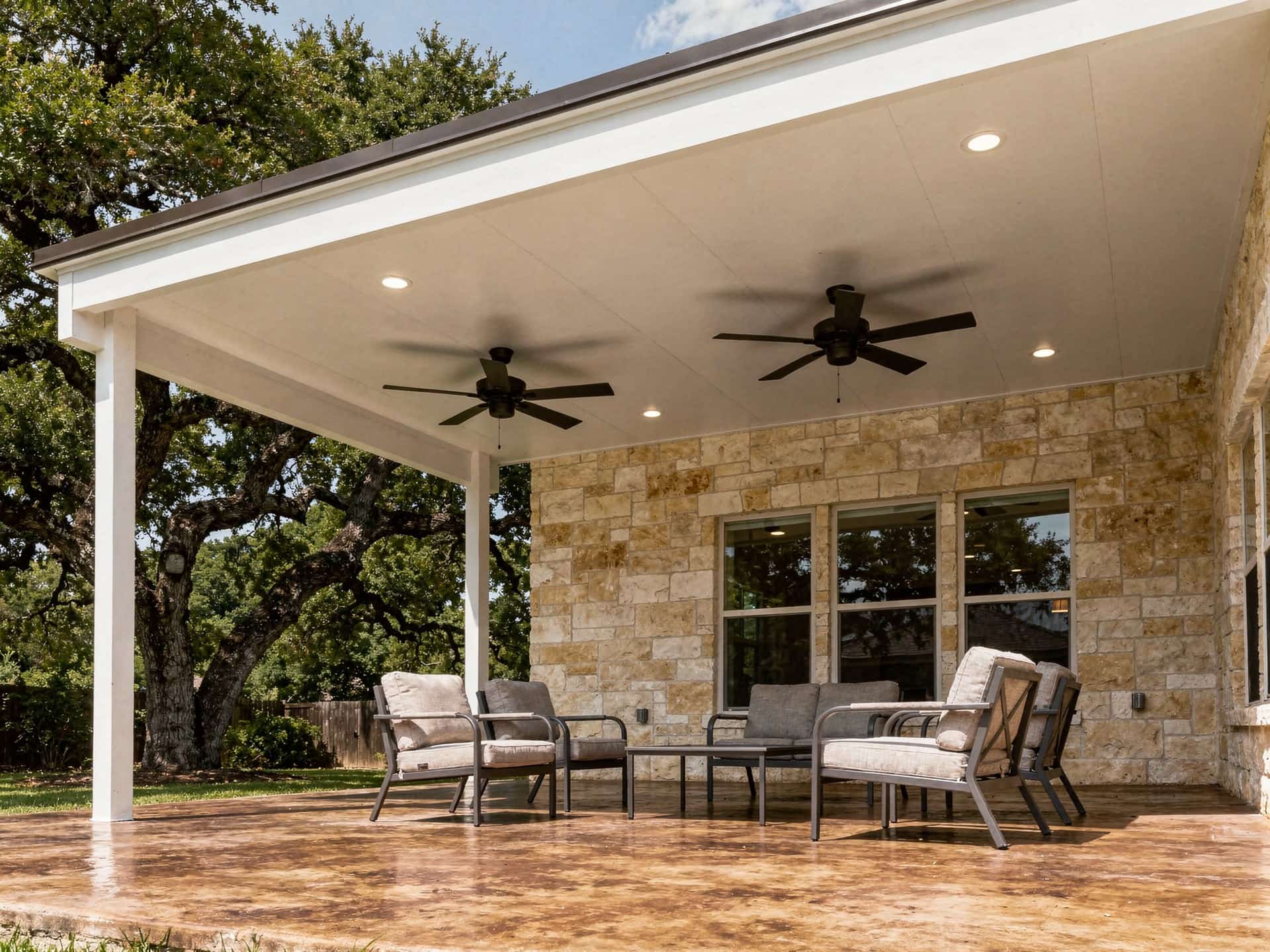Insulated white panel patio cover with two ceiling fans and recessed lights