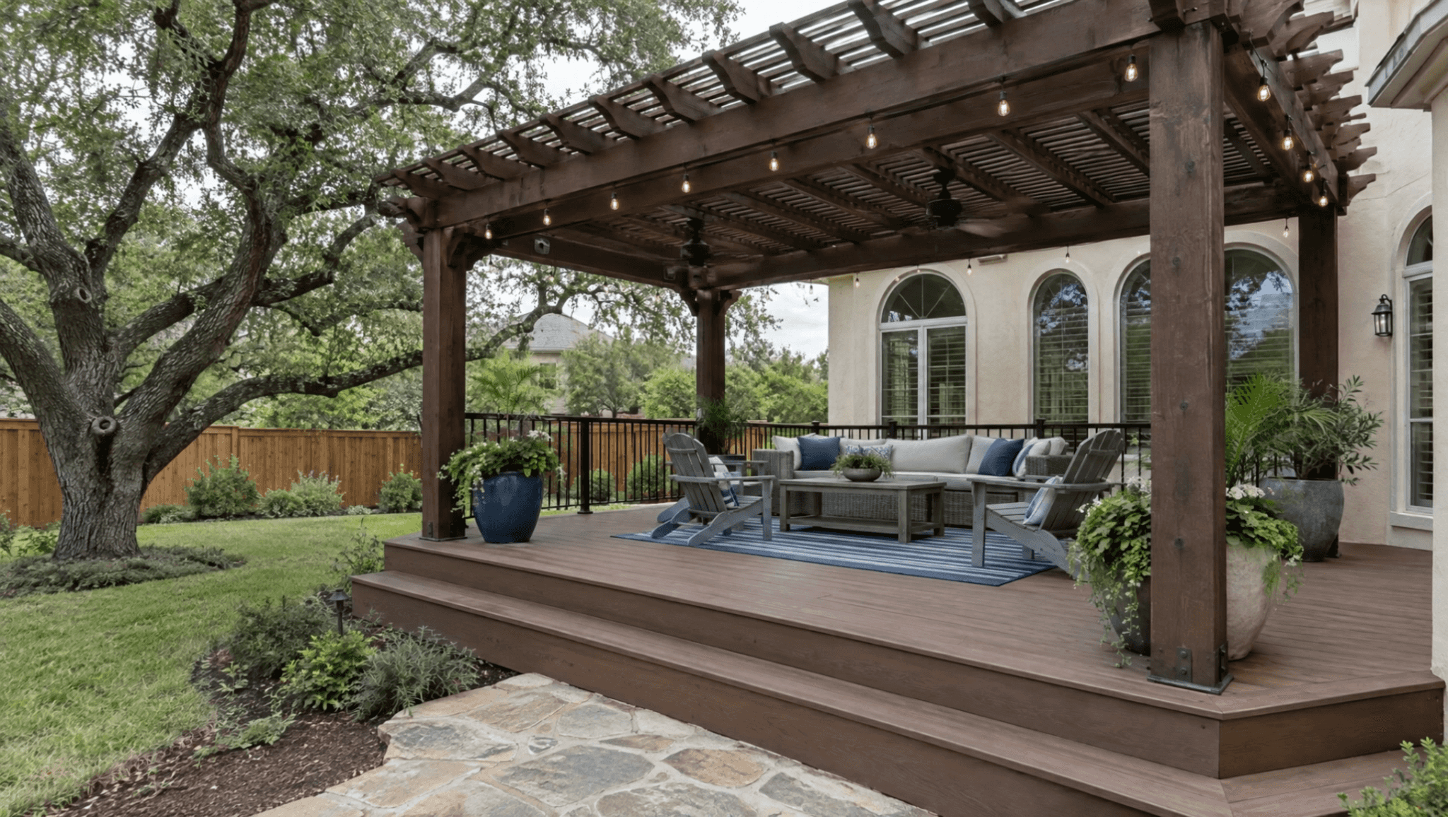 Low composite deck under a stained cedar pergola with string lights
