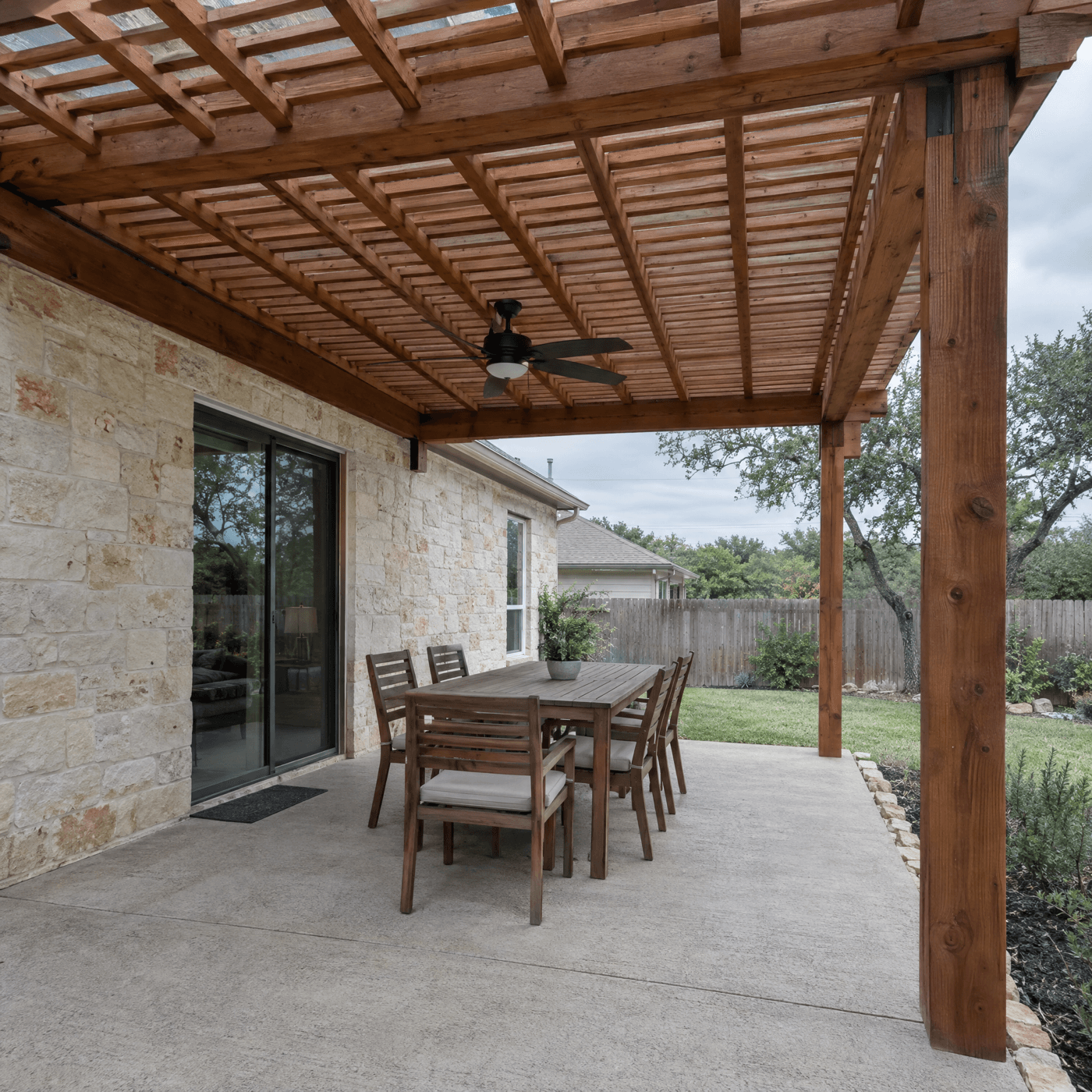 Cedar pergola over a flagstone patio attached to the house roofline